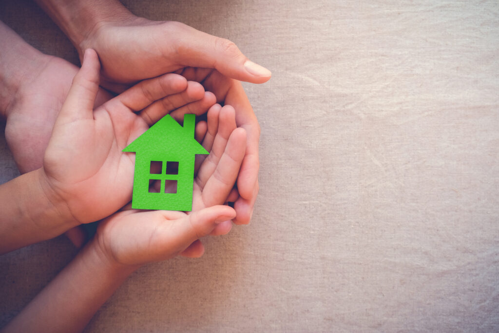 adult,and,child,hands,holding,green,paper,house,,eco,house,